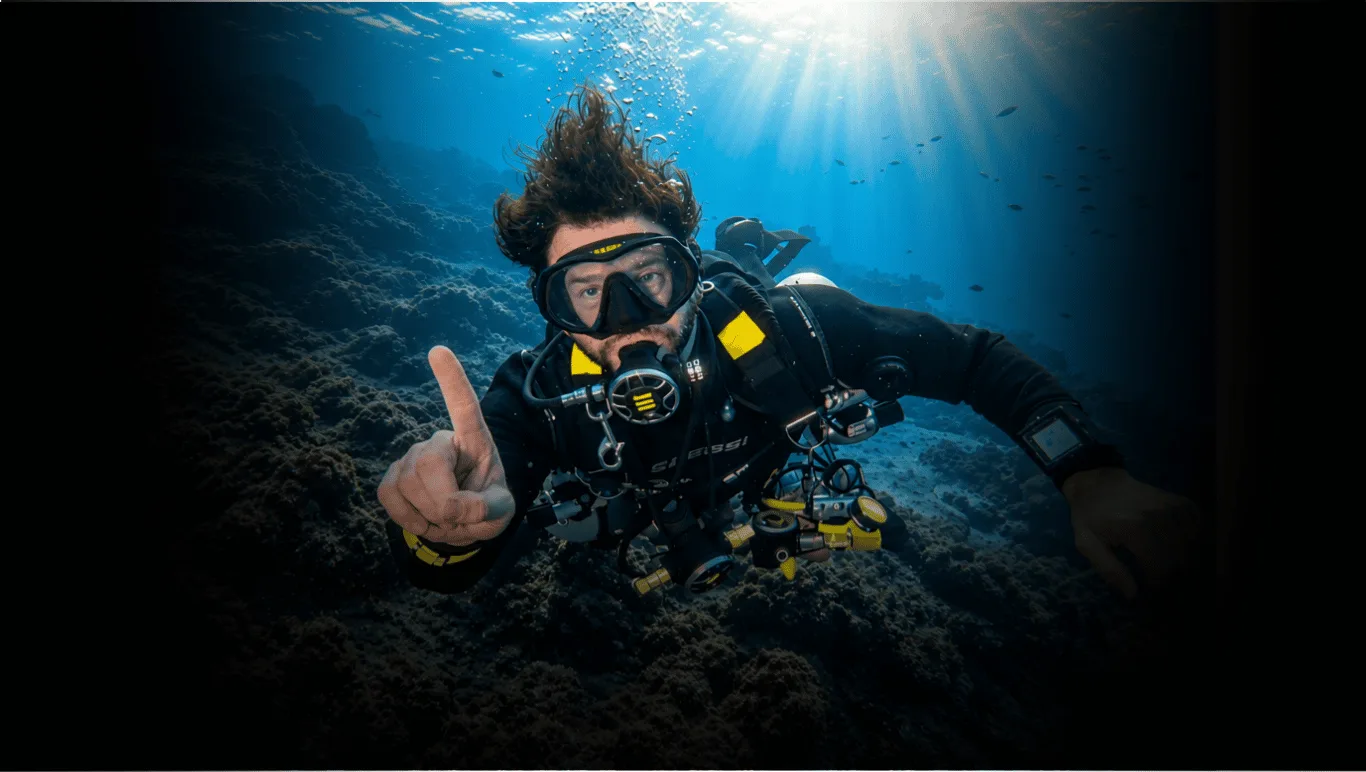 Scott Finch Sidemount diving beneath sunlit water in Gran Canaria