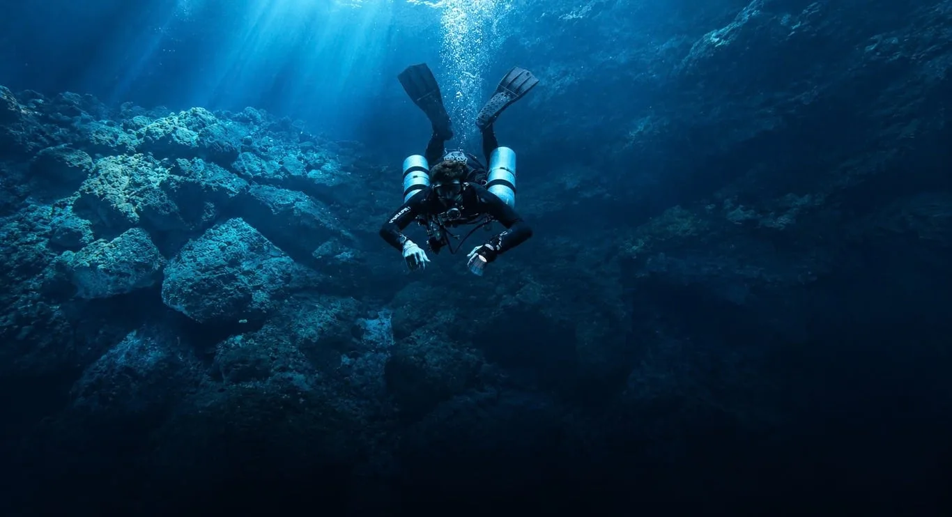 Scott Finch Sidemount diving over volcanic rock in Gran Canaria