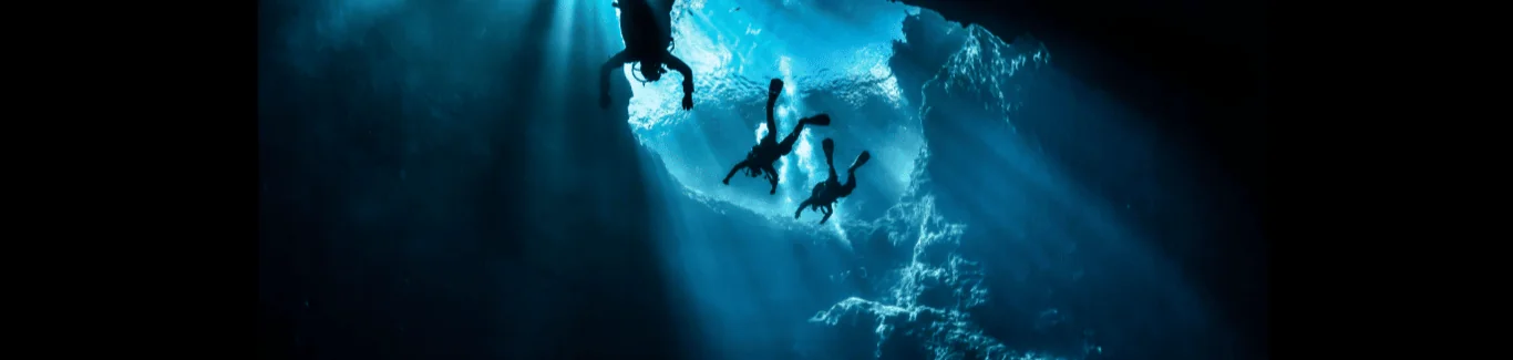 Scott Finch diving beneath a sunlit ocean surface in Gran Canaria